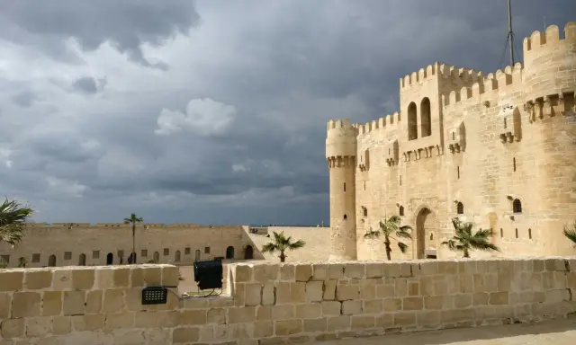 Die Zitadelle von Qaitbay in Aleksandria, Ägypten, ragt unter einem dramatischen Himmel auf.