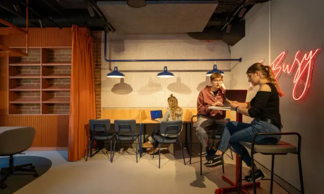 Studenci odbywają praktyki zawodowe w nowoczesnym biurze.