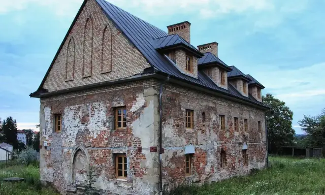 Stary budynek w Bieczu, zniszczony tynk, ceglane ściany, okna z drewnianymi ramami. Jedna z bieckich atrakcji, czekająca na renowację.