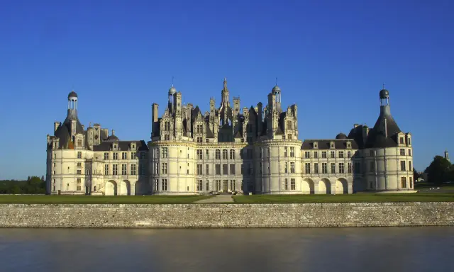 Majestatyczny zamek Chambord, perła Doliny Loary, wznosi się nad spokojną rzeką.