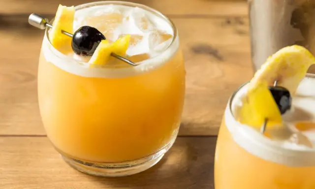 Zwei erfrischende Cocktails mit Zitronenzeste und Kirsche, perfekt für die Liste der 10 beliebtesten Cocktails.