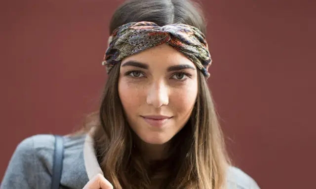 Frau mit braunen Haaren und einem gemusterten Haarband, das ihre Frisur mit Haarband unterstreicht.