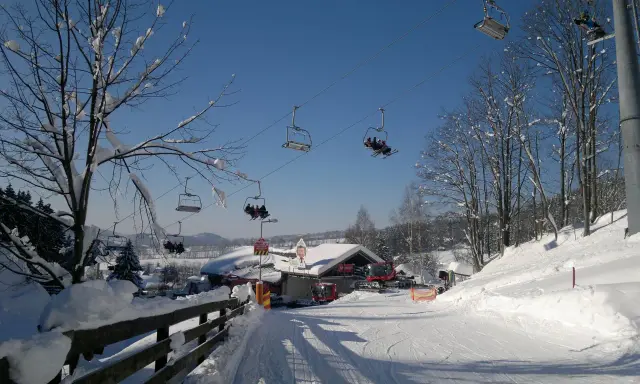 Kolejka krzesełkowa nad ośnieżonym stokiem narciarskim w Rokytnicach nad Jizerou.