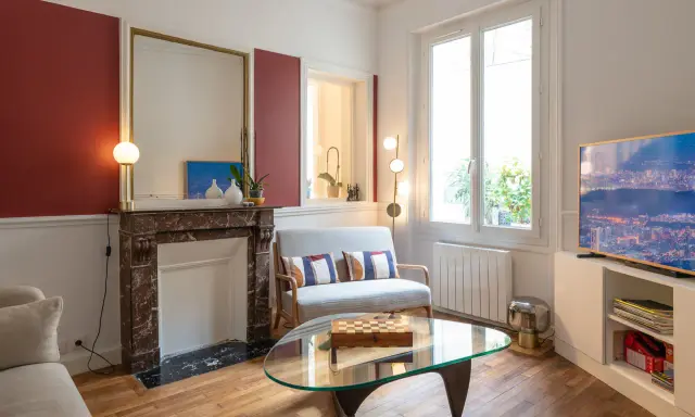 Plan salon 16m2 : cheminée en marbre, canapé gris, table basse en verre avec jeu d'échecs, fenêtre lumineuse.