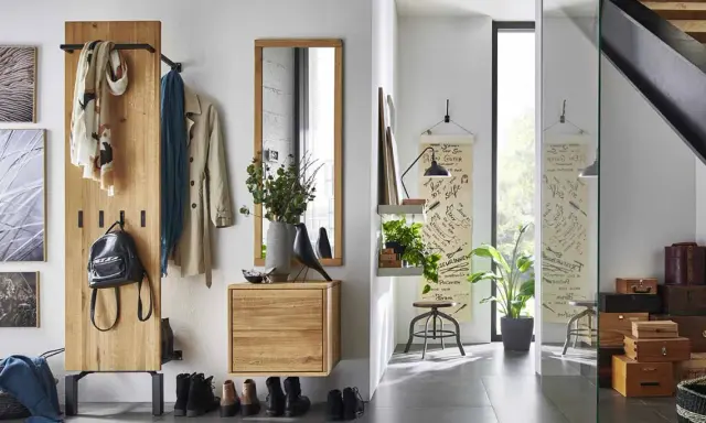 Une entrée chaleureuse avec un porte-manteau en bois, des tableaux, un miroir et des boîtes de rangement. Une belle idée déco pour une entrée de maison fonctionnelle et stylée.