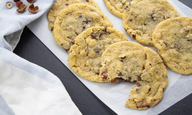 Gros plan sur des cookies aux pépites de chocolat et noisettes, dont le beurre fondu a donné une texture parfaite. Un délice !