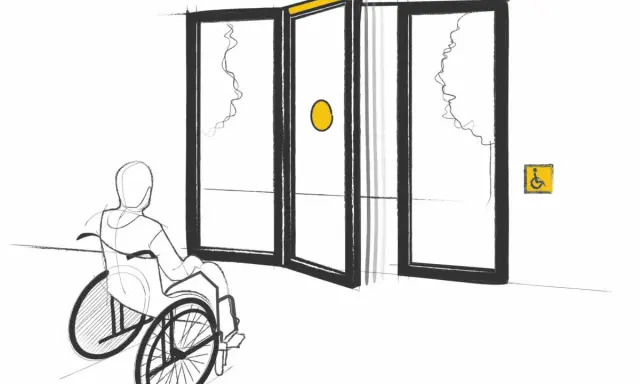 Persona en silla de ruedas se acerca a puertas automáticas, cumpliendo la normativa de puertas de portales para accesibilidad.