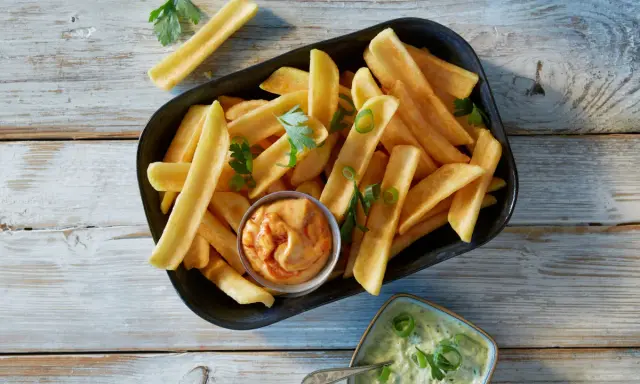 En skål med gyllene pommes frites, perfekt för att doppa i den krämiga såsen till pommes.