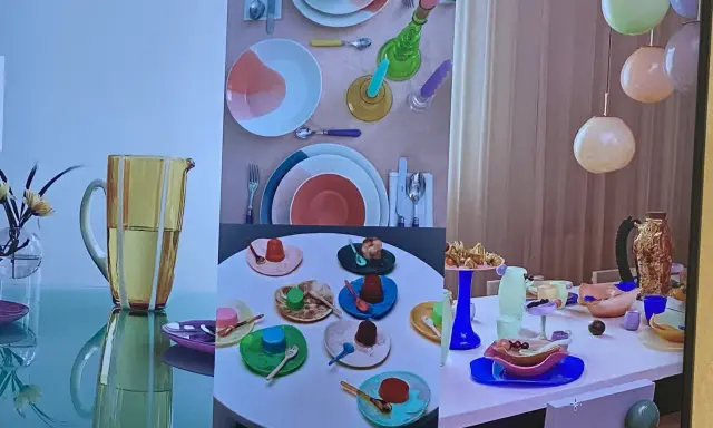 Un joyeux **art de la table française** avec des desserts colorés, des assiettes vives et un pichet jaune.