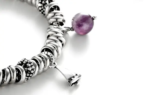 Bracciale con charm e una sfera di ametista, simbolo di pace e spiritualità. L'ametista significato esoterico è noto per la sua capacità di calmare la mente.
