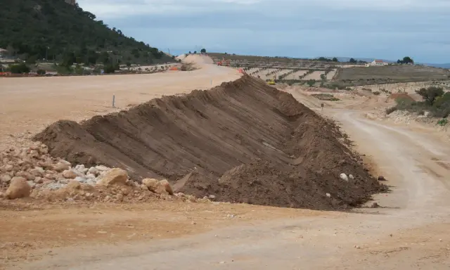 Un terraplén, parte de una obra vial, se eleva con tierra removida. El terraplén significado es la elevación artificial del terreno.