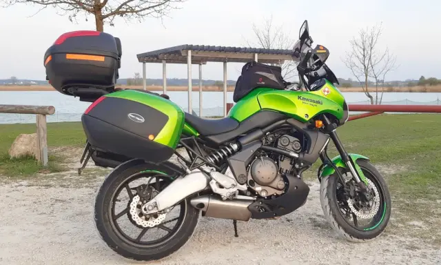 Zielony Kawasaki Versys 650 z kuframi, gotowy na wyprawę. Poznaj jego versys 650 dane techniczne.