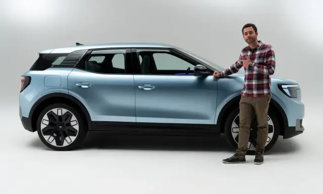 Hombre junto a un coche azul claro, mostrando las medidas del Ford Explorer.