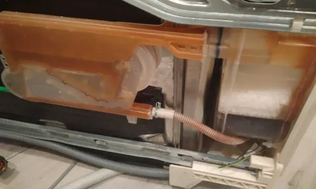 Zmywarka Electrolux z błędem i20. Widoczny zbiornik z brązową wodą i solą.