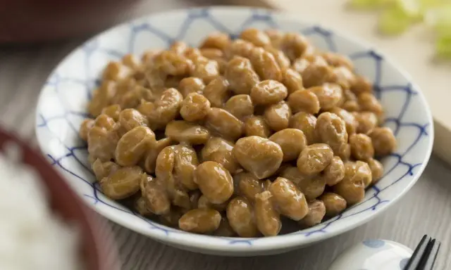 Nattokinaza na co pomaga? Miseczka sfermentowanej soi, czyli natto, z charakterystyczną nitkowatą konsystencją.