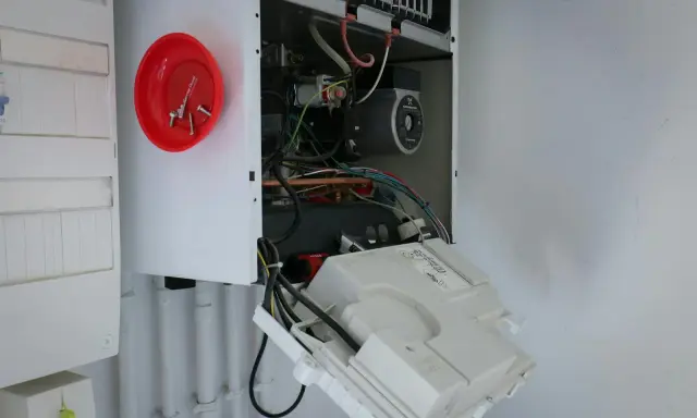 Ouvert pour l'entretien chaudière gaz obligatoire, on voit le circuit électrique et la pompe.