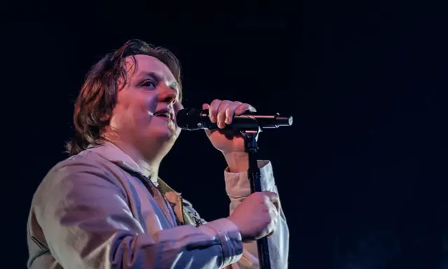 Lewis Capaldi sjunger passionerat på scen i Sverige, med mikrofonen i handen och blicken uppåt.