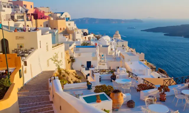 Piękne białe domy na Santorini, idealna pogoda na wrzesień w Grecji. Widok na błękitne morze i kalderę.