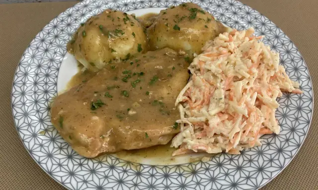 Pyszna pierś z kurczaka w sosie własnym, podana z purée ziemniaczanym i surówką z marchewki i kapusty.