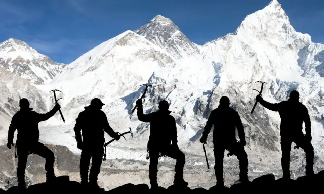 Pięciu alpinistów z czekanami na tle majestatycznego Mount Everestu. Ile osób weszło na Mount Everest? To pytanie zadaje sobie wielu, ale ta grupa już tam dotarła.