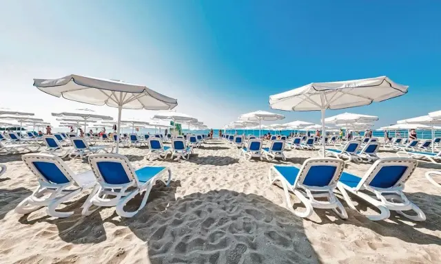 Plaża w Voya Beach Resort Bułgaria, rzędy leżaków i parasoli czekają na gości.