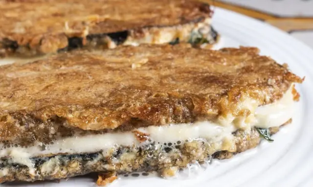 Parmigiana di melanzane ricetta originale: strati dorati e filanti di melanzane fritte, mozzarella e sugo.
