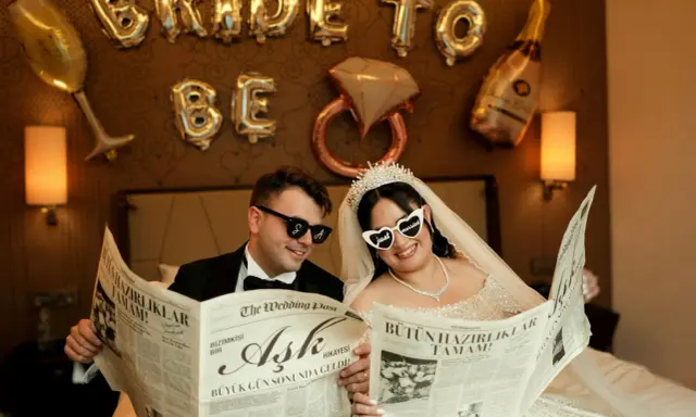 Para młoda czyta gazetę "The Wedding Post" z nagłówkami "Miłość" i "Wszystkie przygotowania zakończone!". Ile pieśni na ślub? Tego nie wiemy, ale na pewno będzie pięknie!