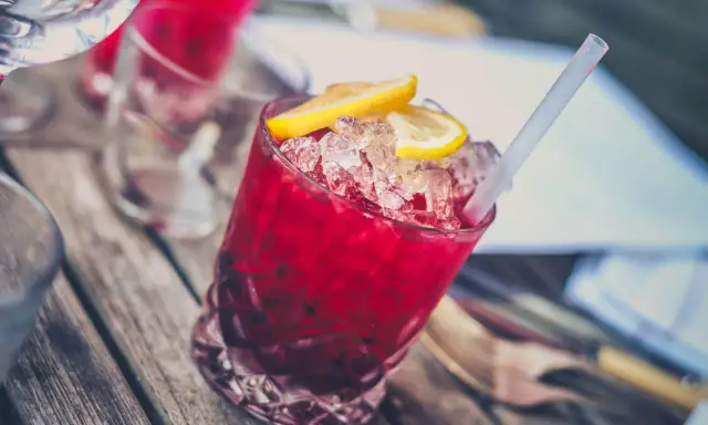 Czerwony drink z lodem i cytryną, z pewnością zawiera grenadynę. Co to jest? Syrop z granatów, idealny do koktajli.