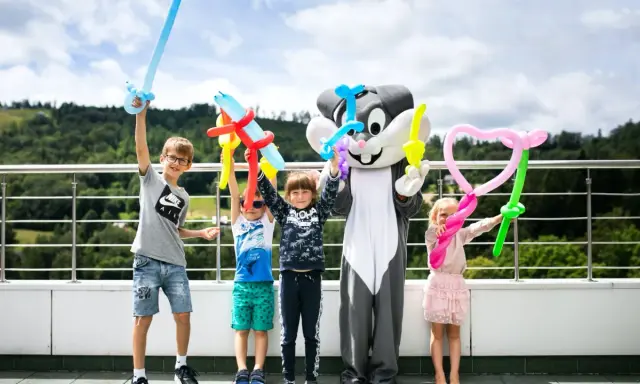 Dzieci z animatorami w strojach postaci z balonów tworzą miecze i serca. Wspaniałe beskidy atrakcje dla dzieci na wakacjach.