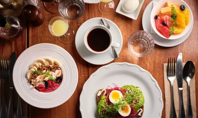 En härlig frukost i Stockholm med en smoothie bowl, avokadotoast, frukt och kaffe.