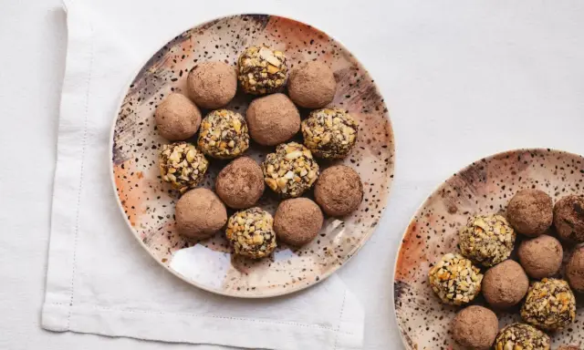 Plato con trufas de chocolate espolvoreadas con cacao y otras cubiertas de frutos secos.
