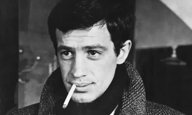 Jean-Paul Belmondo, z papierosem w ustach, w płaszczu, jakby właśnie wysiadł z pociągu do Gdyni.