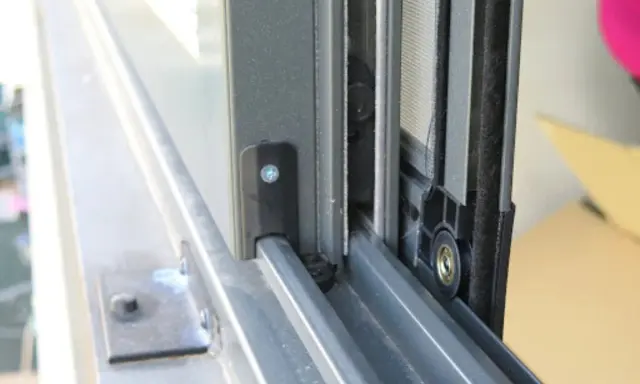 Detalle de cómo hacer una mosquitera corredera: el marco de aluminio y la malla en un riel.