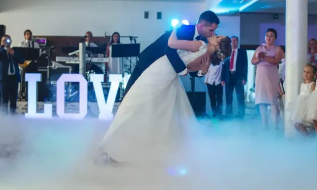 Para młoda tańczy do muzyki na weselu, otoczona mgłą i literami "LOVE". To jak scena z najsłynniejszych baletów.