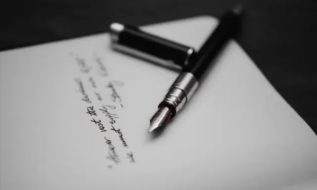Pióro wieczne na papierze, gdzie widnieje fragment tekstu, być może ostatnia wola lub testament.