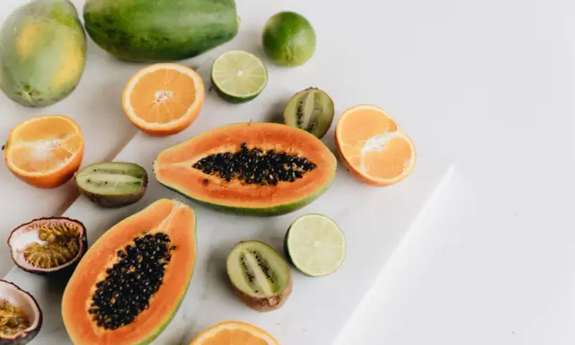Kolorowe owoce: papaja, kiwi, pomarańcze, limonki i marakuja. Czy owoce tuczą? Te na zdjęciu wyglądają zdrowo i pysznie!