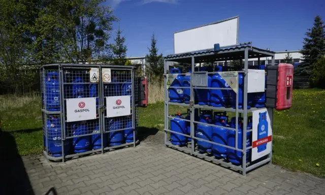 Butle z gazem Gaspol stoją w metalowych stojakach. Zastanawiasz się, ile kosztuje butla z gazem? Sprawdź cenę wymiany.