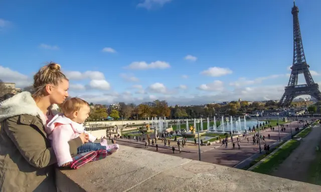 Madre y bebé disfrutan de la Torre Eiffel y las fuentes en Francia con niños.