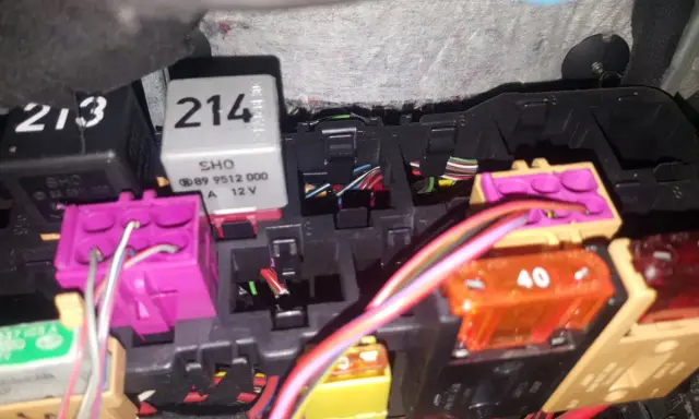 Skrzynka bezpieczników Audi A4 B5 z widocznymi przekaźnikami i kolorowymi bezpiecznikami.