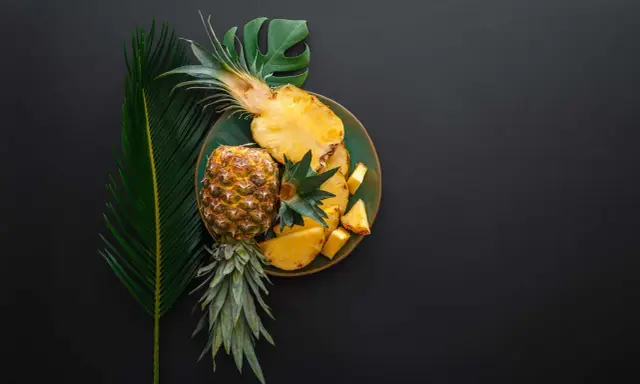 Ananas na talerzu, obok liści. Czy wiesz, że bromelaina co to za enzym?
