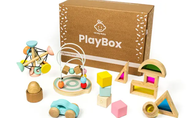 Scatola PlayBox con giochi di precisione in legno: macchinina, abaco, blocchi colorati e forme trasparenti per stimolare la creatività.