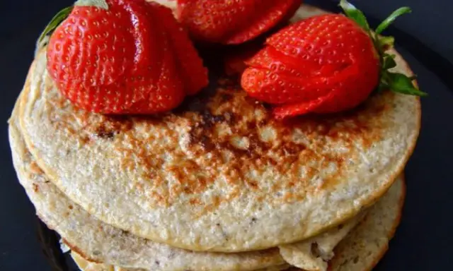 Deliciosas tortitas de avena y plátano, coronadas con fresas rojas y jugosas. Un desayuno perfecto.