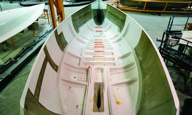 Intérieur d'une coque de bateau en construction, prêt pour le talonnage bateau. Lignes épurées et structure visible.