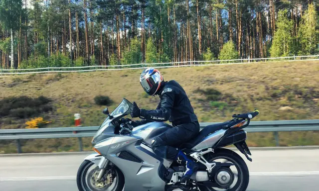 Motocyklista na srebrnej Hondzie VFR 800, mimo że to świetna maszyna, ma swoje wady. Jazda po lesie.
