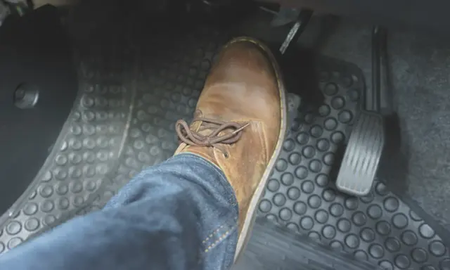Buty na pedale hamulca. Delikatne naciskanie pedału może sygnalizować hamowanie pulsacyjne.