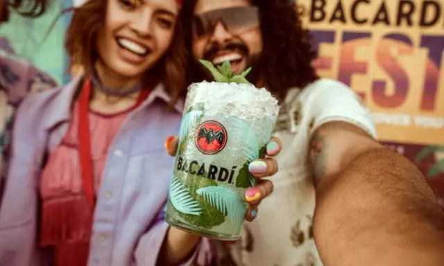 Radosna para świętuje na festiwalu z orzeźwiającym drinkiem Bacardi Mojito.