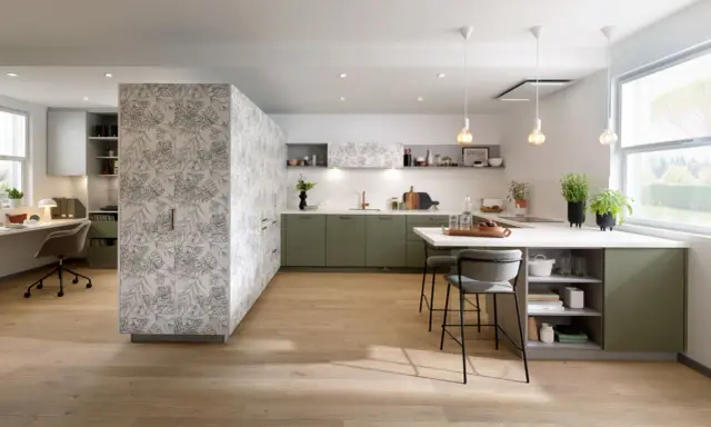 Cuisine moderne avec îlot central, murs décorés de motifs végétaux. Quel mur peindre en couleur ? Les meubles verts s'harmonisent avec le bois clair.