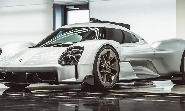 Silberner Porsche Hypercar mit aggressiven Linien und auffälligen Scheinwerfern, bereit für die Rennstrecke.