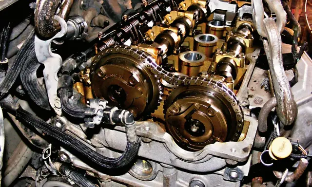 Wnętrze silnika Peugeot 1.6 THP z widocznym łańcuchem rozrządu i wałkami.