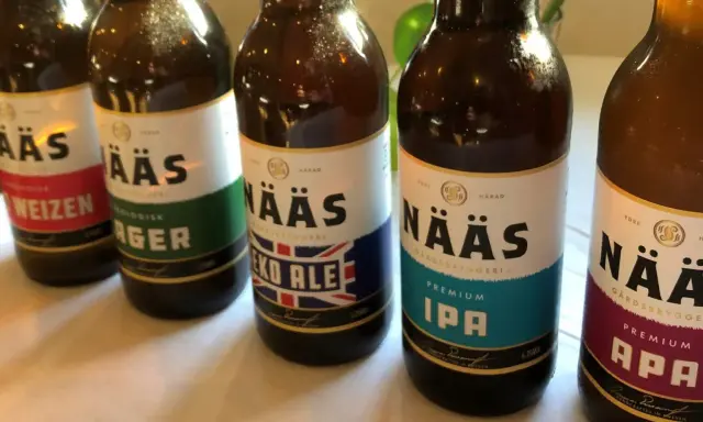 Flera flaskor öl från Nääs bryggeri står uppradade. En flaska med etiketten "Eko Ale" syns tydligt.
